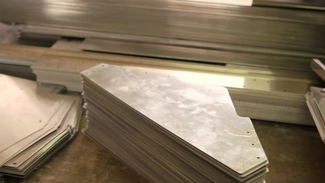 Stack of thin steel parts. Metal sheets on the table. Light aluminium alloys.