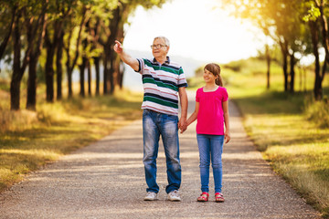 Happy grandfather and granddaughter spending time together in nature.