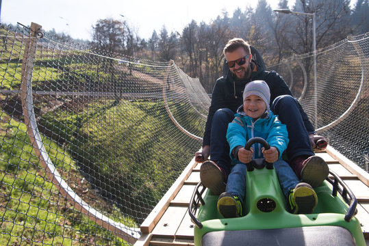 father and son enjoys driving on alpine coaster