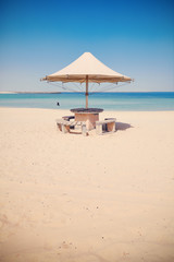 Retro toned picture of an umbrella on an empty tropical beach.