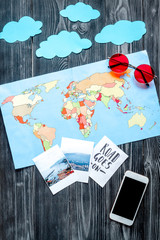 tourist equipment with mobile and map for traveling with kids on dark background top view mock up
