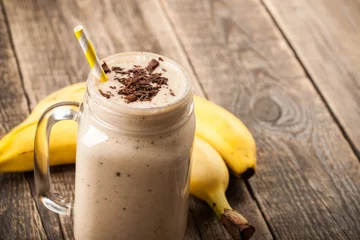 Papier Peint photo Lavable Milk-shake Smoothie au chocolat banane et banane sur table en bois