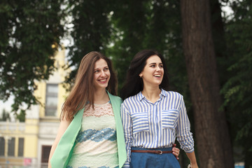 Fototapeta premium Two happy women walking in the summer park