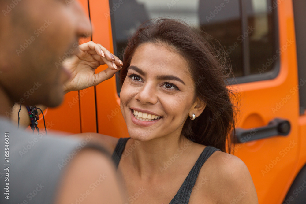 Wall mural Close up of a smiling young woman talking to a guy