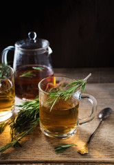 Obraz na płótnie Canvas Herbal tea with aromatic rosemary on wood table