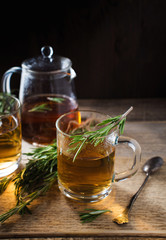 Herbal tea with aromatic rosemary on wood table