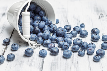 American blueberries scattered over white wooden background