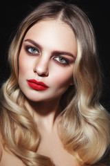Fototapeta premium Young beautiful glamorous woman with red lipstick and blonde curly hair