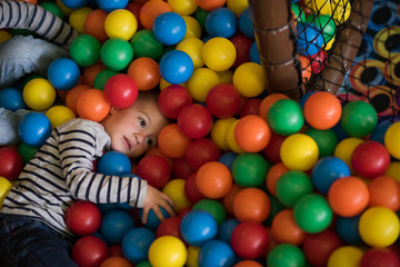 boy having fun in hundreds of colorful plastic balls