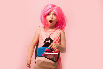 Girl in dress with backpack. Kid with alarm clock