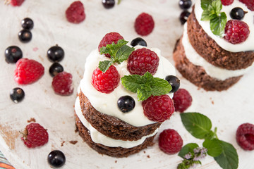 Chocolate cake decorated with raspberry, black currant, wipped cream and mint.