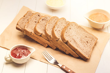Close-up of slice of toast bread with jam and butter on wood table