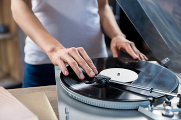 Cropped, close-up image of woman using vinyl audio player