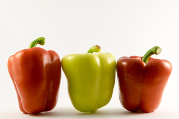 colored peppers over white background