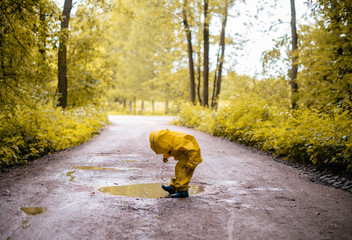 Little girl jumping fun in a dirty puddle