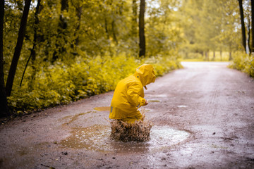 Little girl jumping fun in a dirty puddle