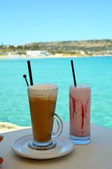 Milkshake made of fresh ripe strawberry on a sea background