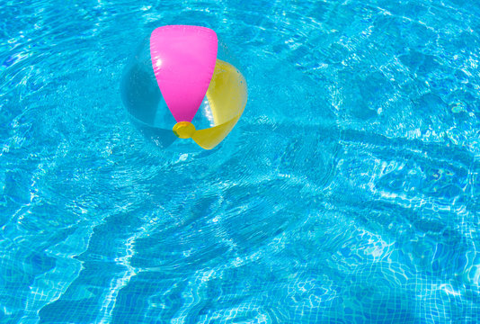 Summer background, colorful inflatable water ball floating in swimming pool