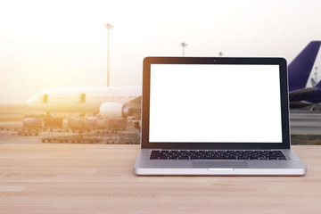 Technology for comfortable travel, tourist, traveler concept : Blank white screen on notebook , laptop with airport and blur airplane background , film effect.