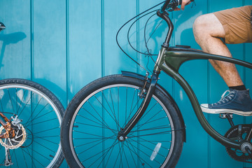 Unrecognizable Young Cyclist Sitting With A Bicycle Along A Blue Wall Background Daily Lifestyle Urban Resting Concept