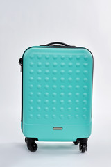Blue textured suitcase for travel. Wheeled blue bag for clothes. Relocate with modern case.