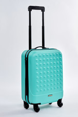 Modern large suitcase on wheels. Traveler wheeled bag, white background.