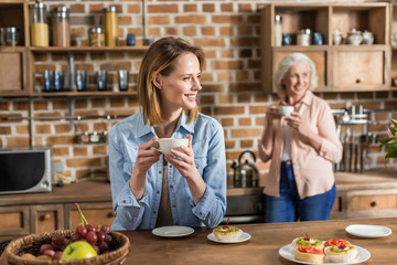 two women, senior and young having good time in kitchen