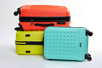 Stylish suitcases on white background. Different colors luggages. Bags for clothes to the sea.