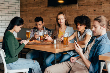 Group of young multiethnic friends spending time in cafe