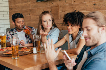 Group of young multiethnic friends spending time in cafe