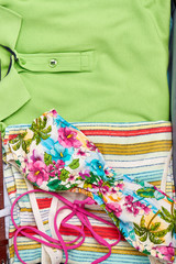 Summer colorful clothing macro. Man shirt and woman flowery swimsuit.