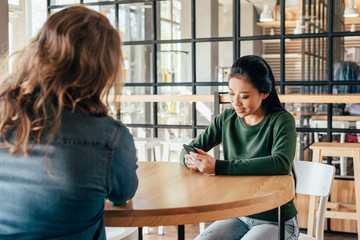 Portrait of young asian woman spending time with friend in cafe