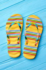 Summer fashion striped sandals. Colorful flip flops on blue background.