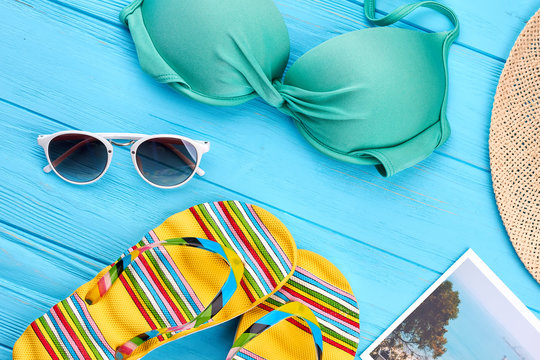 Woman beach accessories close up. Colorful bra, sandals, glasses, panama, picture.
