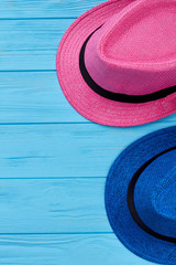 Pair of hats close up. Vertical image of blue and pink hat, wooden background.