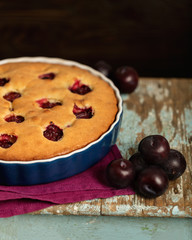 Rustic style. Homemade plum cake on a purple linen napkin.