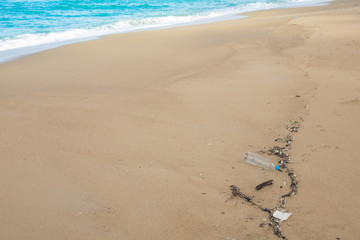 Plastic bottles and other waste on sea beach .
