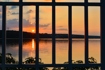 Sunset over a lake, sky. Lattice. Prison.