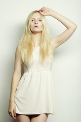 young fashion woman in white dress posing in studio