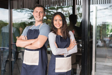 two cafe owner smiling to camera in the cafe