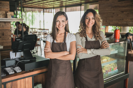 two beautiful female cafe owner smiling proudly