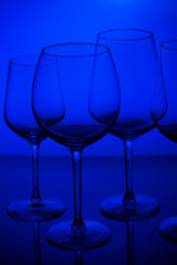 Set of empty wine glasses on blue background
