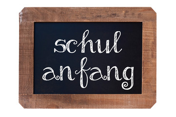 Fototapeta premium Schulanfang (meaning Back to school) written on a vintage blackboard with wooden frame isolated on white background