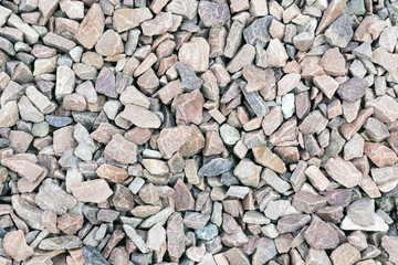 Small rock crushed stone road-metal. Pile of white, grey and yellow rocks. Road-metal background