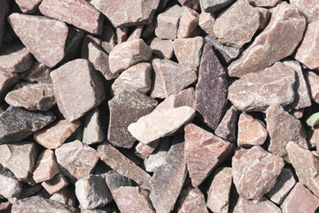 Small rock crushed stone road-metal. Pile of white, grey and yellow rocks. Road-metal background