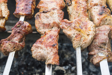 Skewers of pork or meat fried on a barbecue on the grill, barbecue