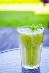 Raw Green Smoothie on the Table in the Garden, Summer Time, Vertical View