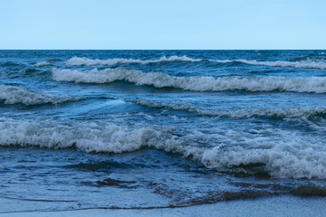 blue water sea side waves in evening after sunset light