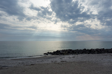 Fototapeta na wymiar Black Rocks In The Sea At Hiddensee Island Beach Before Sunset