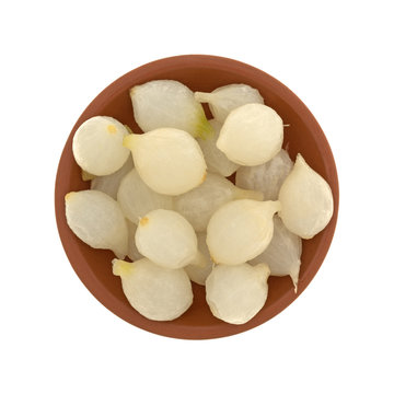 Top view of a small bowl filled with cooked pearl onions isolated on a white background.